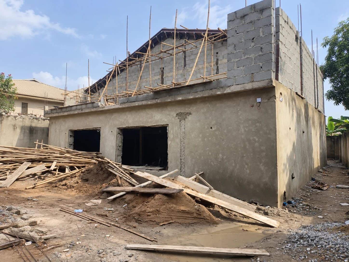 The Vibe Abuja from outside during its renovation: rendered block walls, bamboo scaffolding and a new roof
